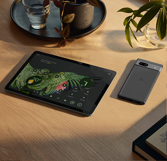 Google Pixel-nettbrett og Pixel-smarttelefon ved siden av hverandre på et trebord