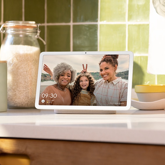 Google Pixel Tablet på et kjøkken som viser et familiebilde av en bestemor, mor og datter