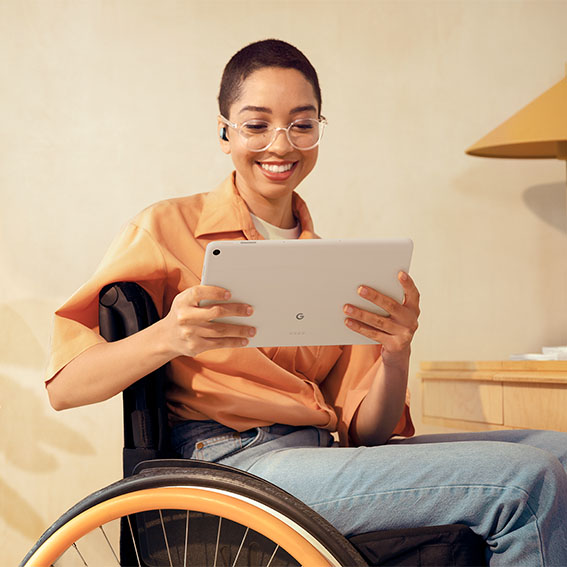 Kvinne i rullestol som bruker Google Pixel-nettbrett i hjemmet sitt