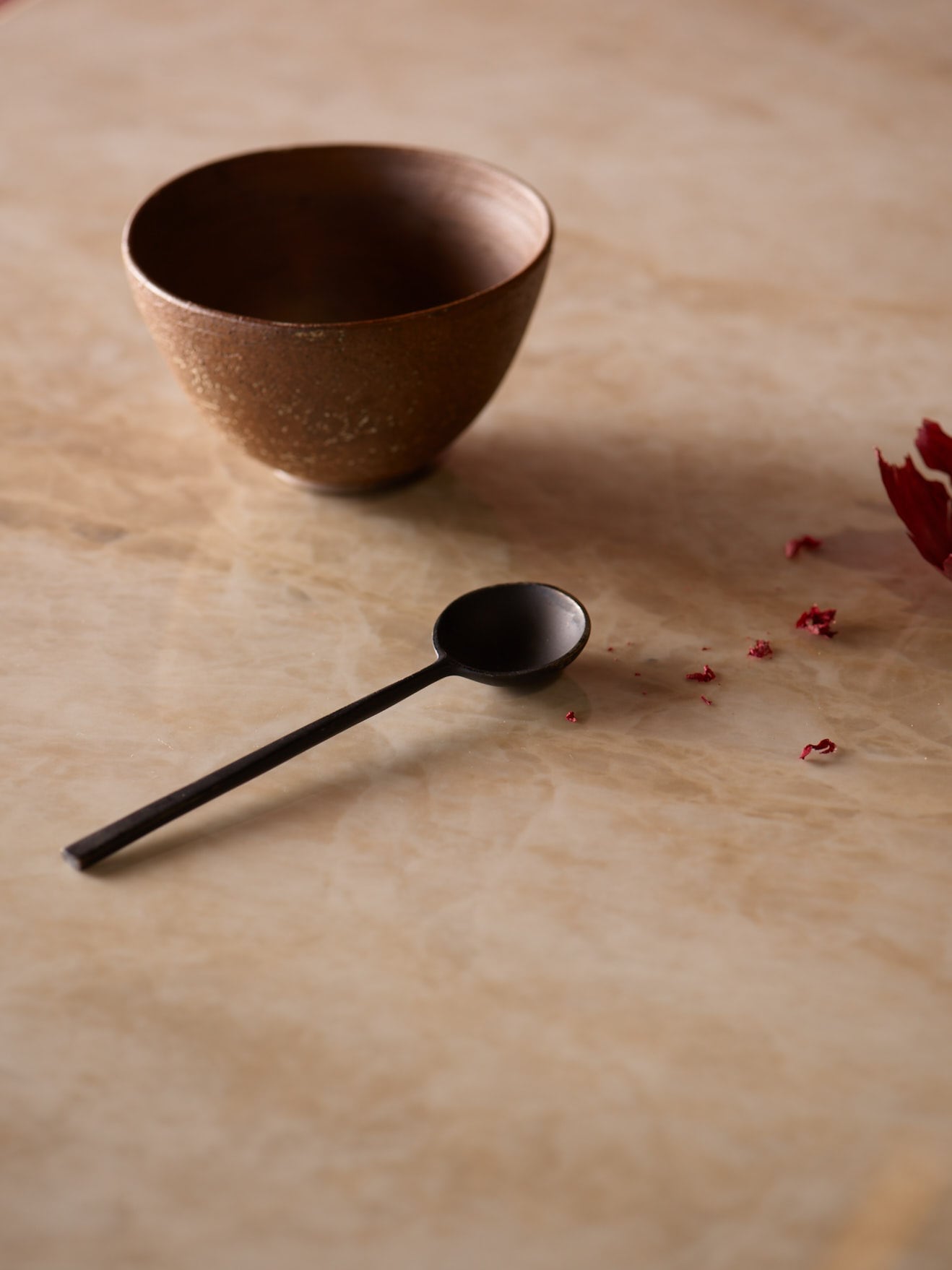 Spoon and bowl on a brown worktop