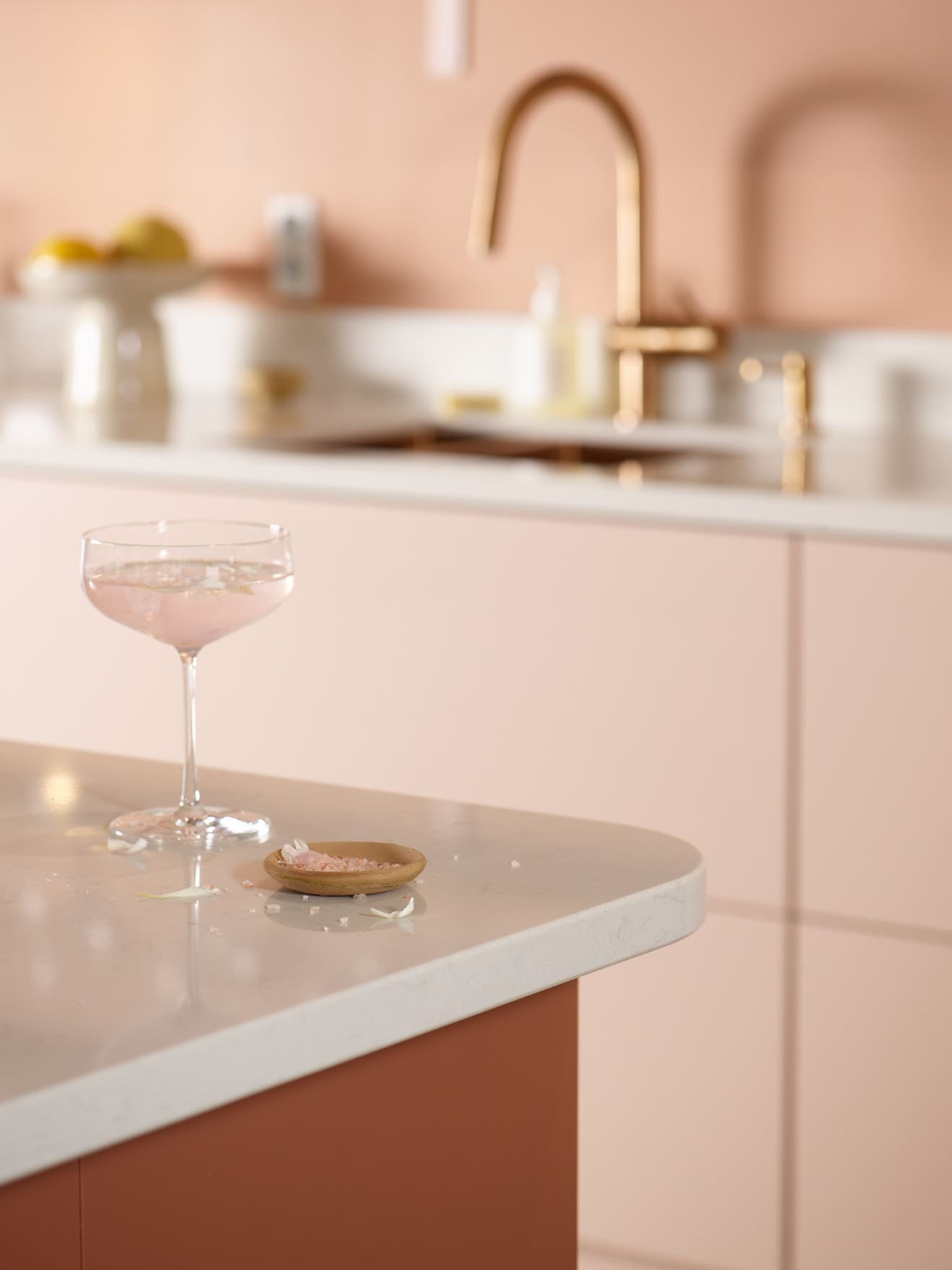 Trend blush colored kitchen and a cocktail on a worktop