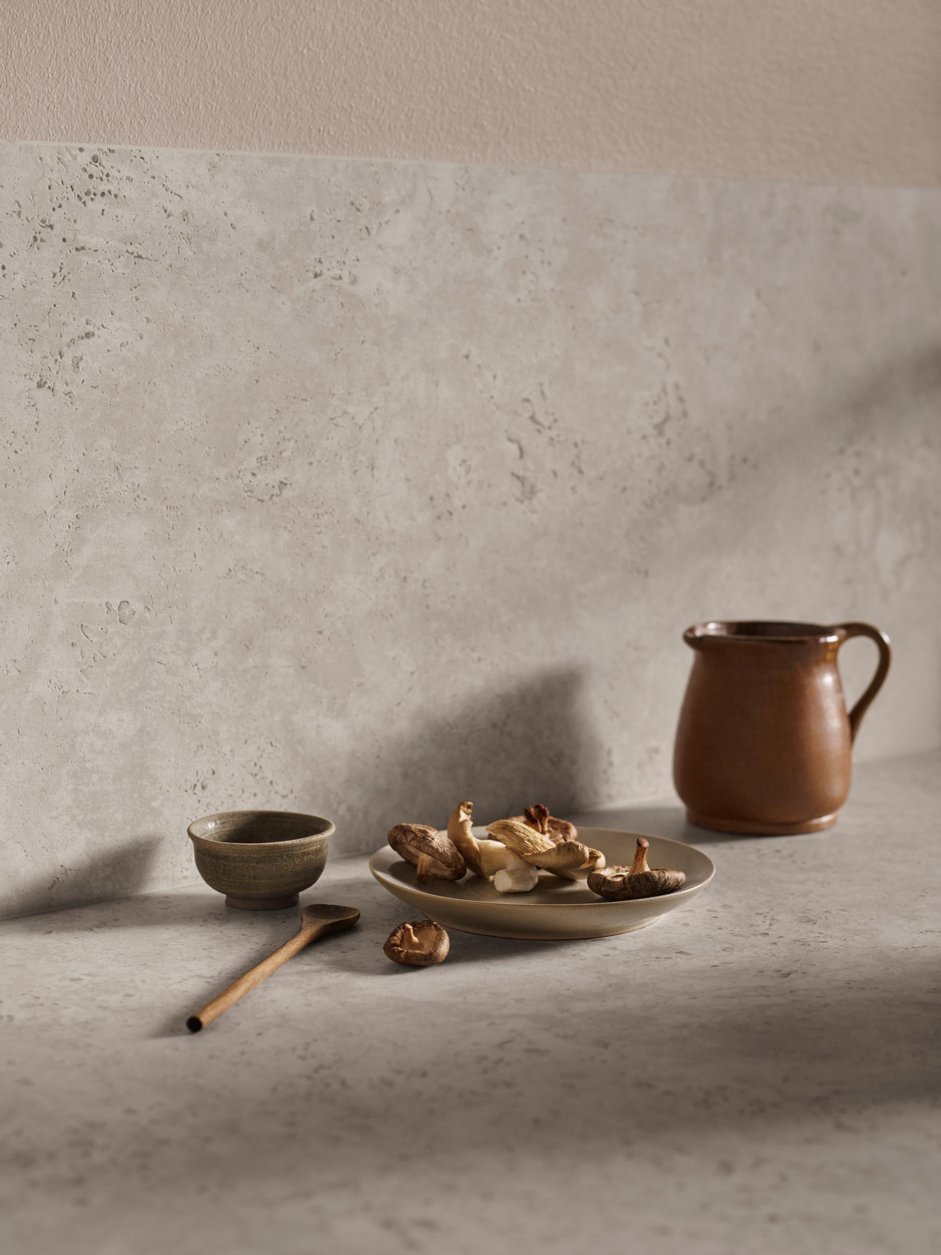Spoon, plate, jug and bowl on a grey-brown worktop