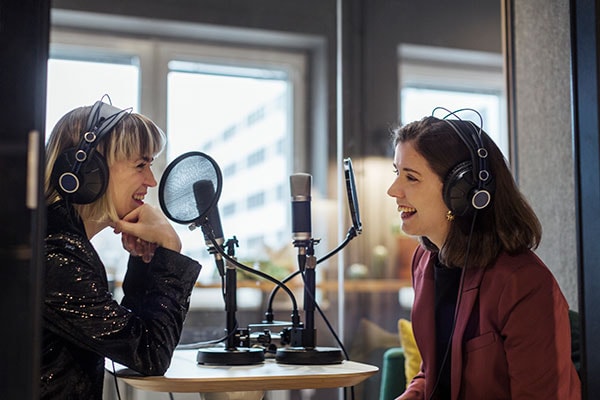 to kvinner spiller inn en podcast