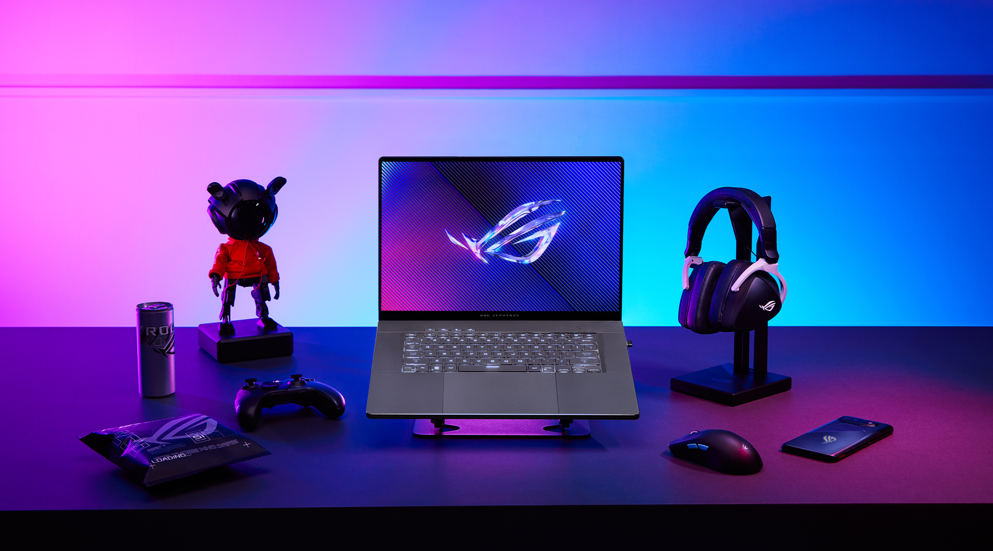 Asus ROG Zephyrus G14 G16 gaming-PC, hodetelefoner, mus og gamingkonsoll på en fargerik bakgrunn