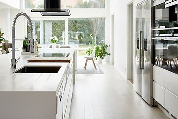hvitt kjøkken med amerikansk dobbelt kjøleskap og hvite integrerte hvitevarer