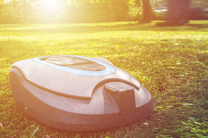 robotgressklipper på gressplen i solskinn