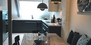 mørkt kjøkken fra epoq med spisebord i front