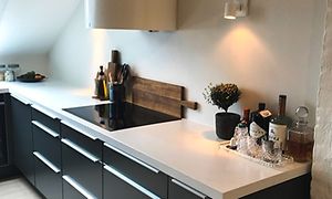 hvit uttrekkbar hood og sorte skuffer under en kjøkkenbenk fra epoq med intergrert ovn