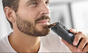 mann trimmer skjegget sitt med en Philips Series 7000 trimmer
