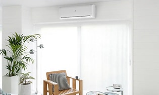 varmepumpe henger på hvit vegg over vindu i stue
