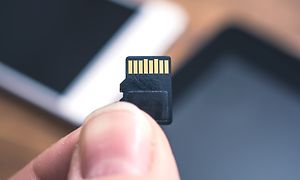 Micro-SD minnekort holdes mellom to fingre