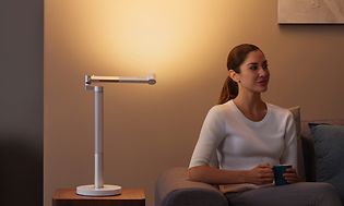 Dyson Lightcycle bordlampe som lyser opp en vegg