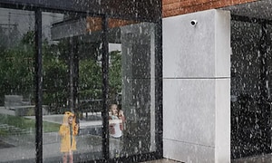 barn ser ut av vindu med regn og overvåkningskamera utenfor