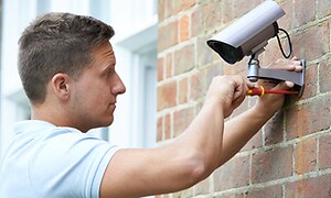 mann monterer overvåkningskamera utendørs