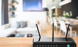 svart trådløs router på bord i stue