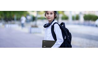 En ung gutt som bærer en Acer Chromebook