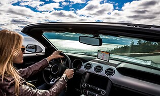 kvinne kjører med Garmin GPS som gir instruksjoner