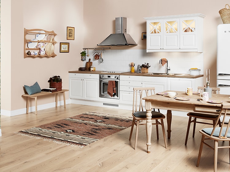 Hvitt Epoq Heritage kjøkken med åpen løsning og møbler i tre