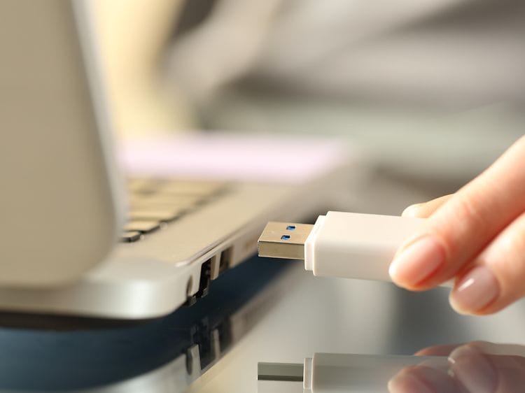 kvinne kobler til en usb USB flash drive til en bærbar pc