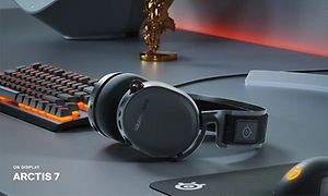 SteelSeries Arctis 7 på et bord med PC-oppsett for gaming og et trofé