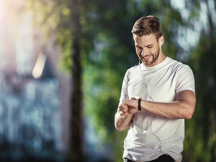 En mann som bruker en sportsklokke til trening