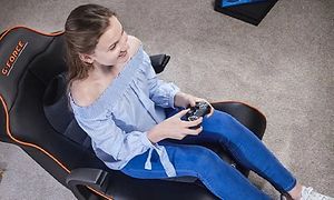 Kvinne sitter i en X Rocker gaming-stol og spiller et konsoll-spill