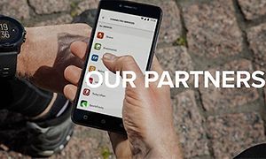 person holder smarttelefon med liste over alle Suuntos partnere