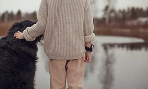 barn med Xplora X5 smartklokke klapper en hund sett bakfra
