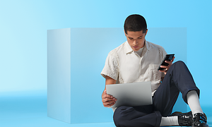 Mann som sitter med en PC og en smarttelefon