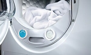 nærbilde av Miele vaskemaskin med åpen dør med hvite klær på innsiden