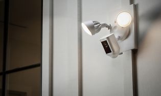 Ring utendørs overvåkningskamera med flombelysning montert på en vegg