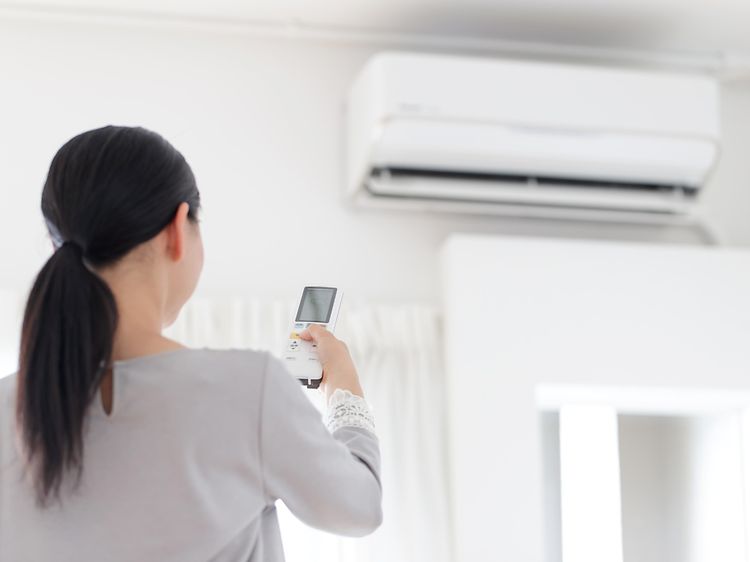 En kvinne som slår på en aircondition