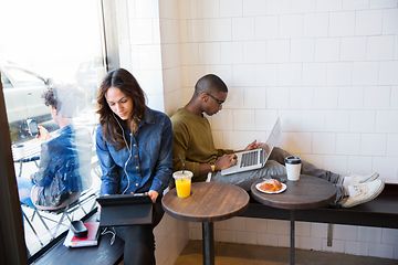 To personer som sitter i en kafé med bærbare PC-er