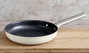 Hvit stekepanne fra Smeg på en skjærefjøl