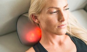 kvinne ligger på en sofa og masserer nakken sin med en YouCare mini massasjepute