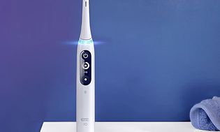 Oral-B iO Serie 7 hvit elektrisk tannbørste i lader på et bord