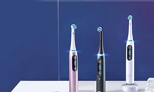 Oral-B i09 elektrisk tannbørste i tre ulike farger på et bord