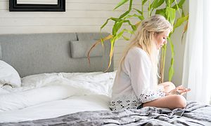 En kvinne sitter på en seng