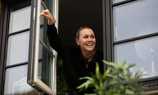 En kvinne åpner et vindu