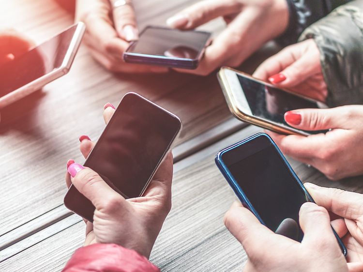 Hender som holder smarttelefoner