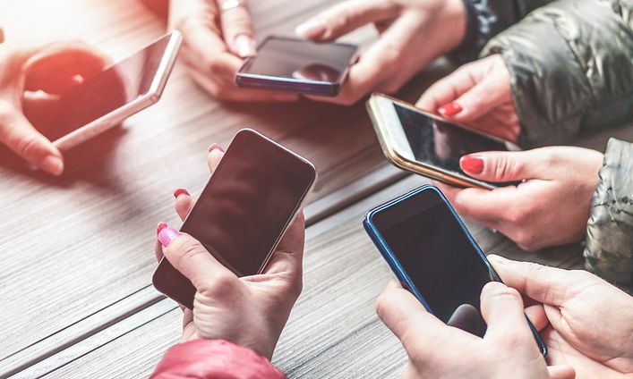 Hender som holder smarttelefoner
