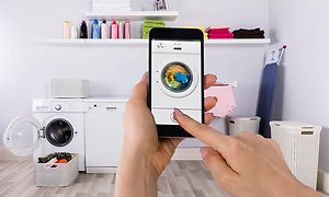 Person som bruker vaskemaskinapp på smarttelefon