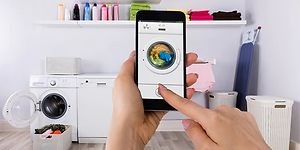 Person som bruker vaskemaskinapp på smarttelefon
