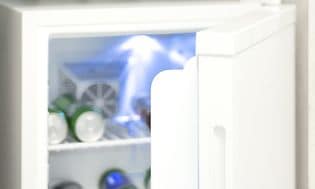 nærbilde av et minikjøleskap med døra åpen og drikkevarer inni
