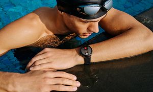 Huawei Watch 3 på armen til en mannlig svømmer i et basseng