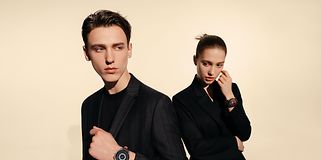 Huawei Watch 3 på armen til en mann og en kvinne kledd i svarte klær
