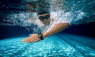  Huawei Watch 3 på armen til en mannlig svømmer under vann