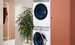 White washer and dryer integrated in cabinets in a modern washroom