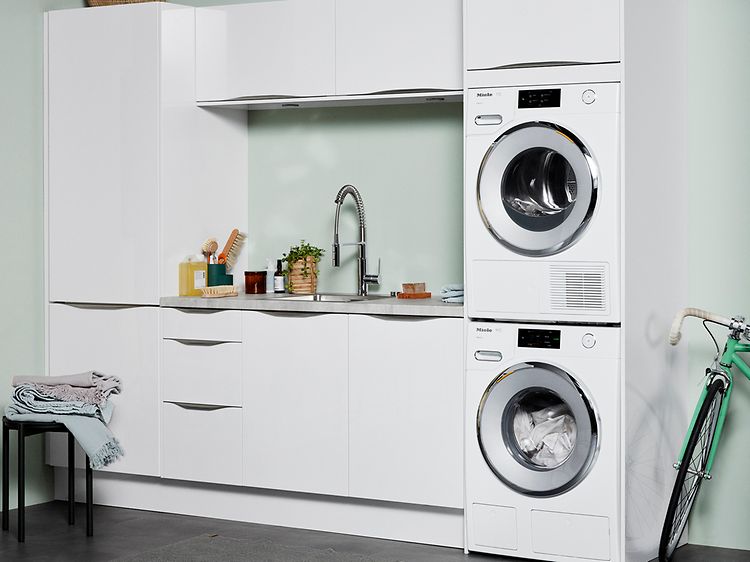 Washer and dryer in a laundry room with white and green interior