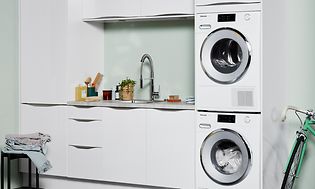 Washer and dryer in a laundry room with white and green interior